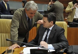 Ignacio Higuero (izda), consejero de Gestión Forestal y Mundo Rural, charla con Abel Bautista, consejero de Presidencia, en la Asamblea de Extremadura.