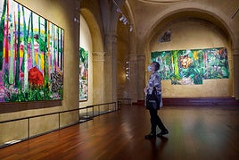 Visitantes contemplan los diferentes lienzos que superan los dos metros de altura.