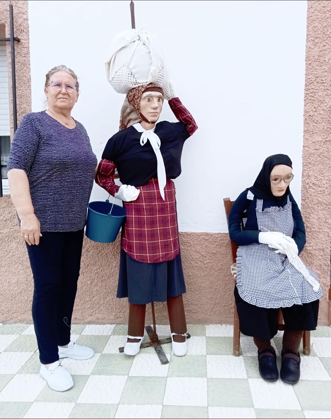 Francisca Cordero, junto a los dos mastros que ha elaborado y que ha expuesto en la puerta de su casa en la calle Libertad.
