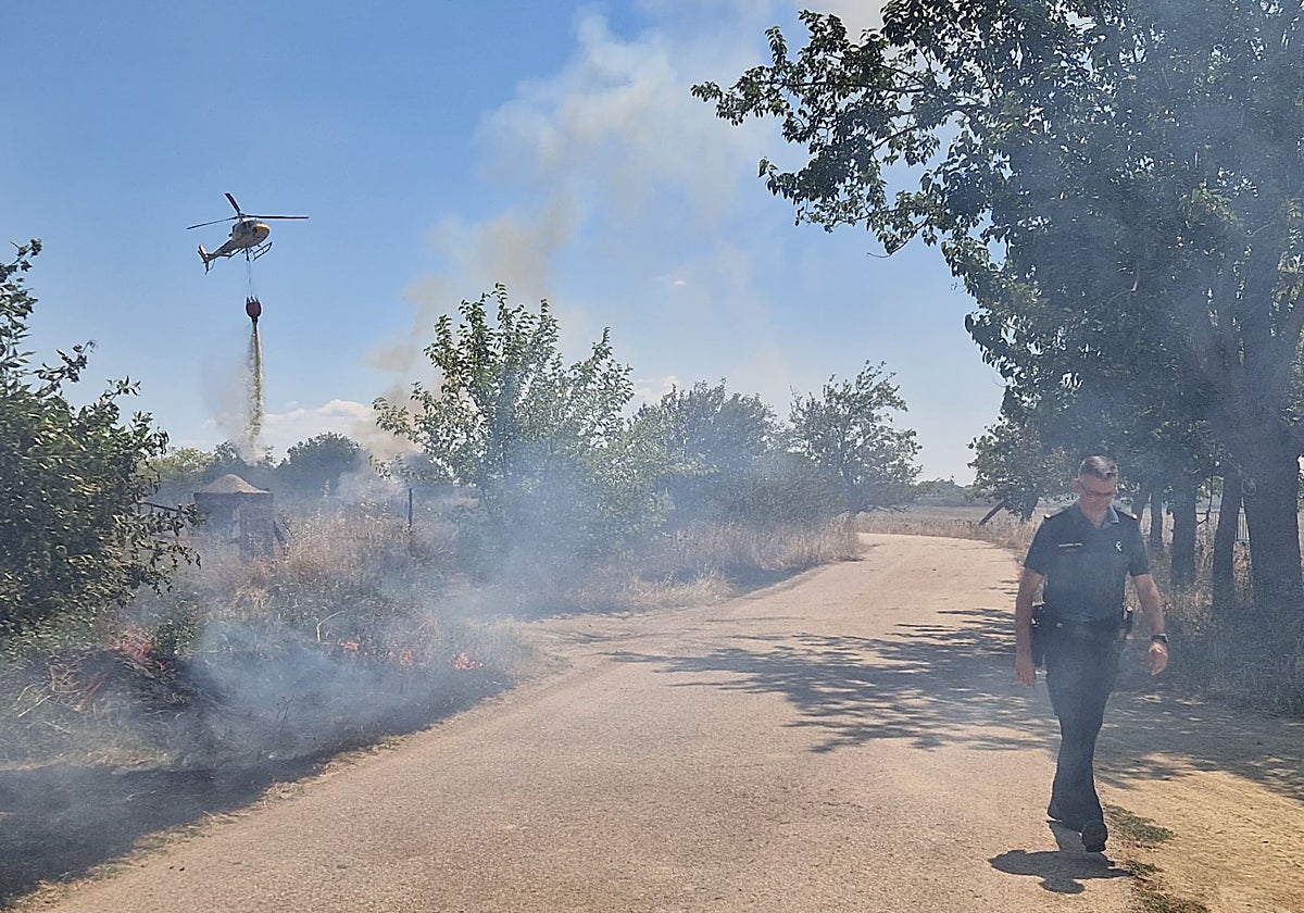 Un helicóptero descarga sobre la zona afectada por el incendio este lunes.