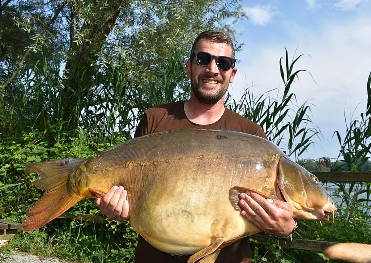 Imagen secundaria 1 - Arriba, Jairo Canchado y Alberto Cacho, con la carpa pescada. Abajo, Alberto Cacho, cogiéndola antes de ser pesada con una báscula.