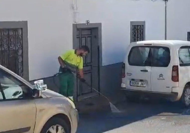 Un operario de la limpieza limpia el lugar de la calle Belén donde ha aparecido el cadáver.