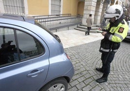 Un policía pone una multa en plaza de España.