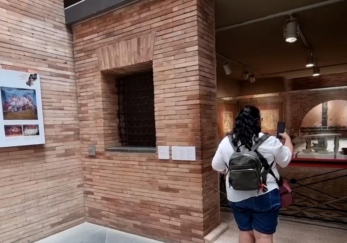 Una mujer observa una exposición del Museo Nacional de Arte Romano de Mérida sobre el interior de una 'domus'.