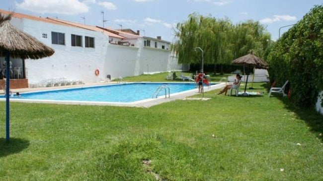 Imagen antes - Imagen de la piscina de Táliga antes de su cierre en 2022 y foto de coómo estaba el pasado 3 de mayo pasado. En junio el Ayuntamiento desbrozó para impedir más hierbas.