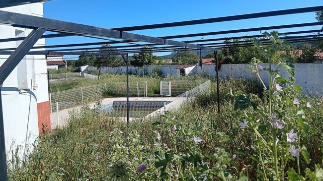 Imagen después - Imagen de la piscina de Táliga antes de su cierre en 2022 y foto de coómo estaba el pasado 3 de mayo pasado. En junio el Ayuntamiento desbrozó para impedir más hierbas.