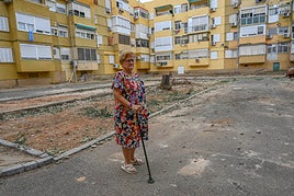La madre de María Dolores Cantero junto a su vivienda, a la que es difícil acceder por el estado de la acera.