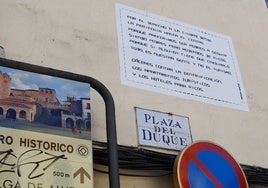 El cartel, sobre fondo blanco, ha aparecido pegado sobre una pared en la Plaza del Duque de Cáceres.