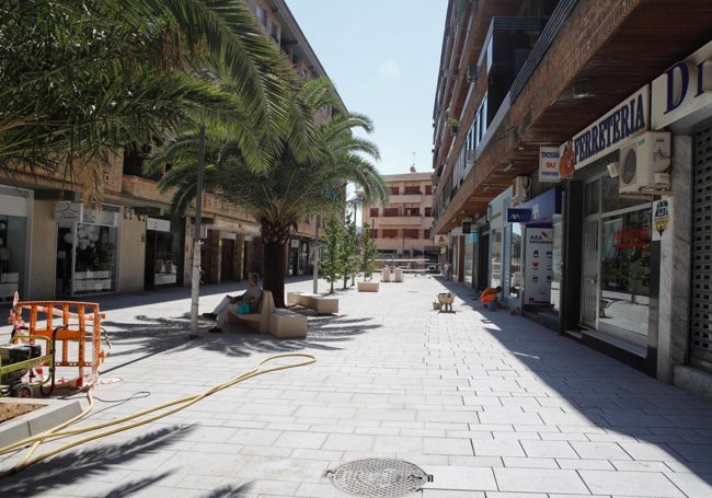 Cacereño utilizando uno de los nuevos bancos de la calle Rodriguez Moñino, que continúa en obras.