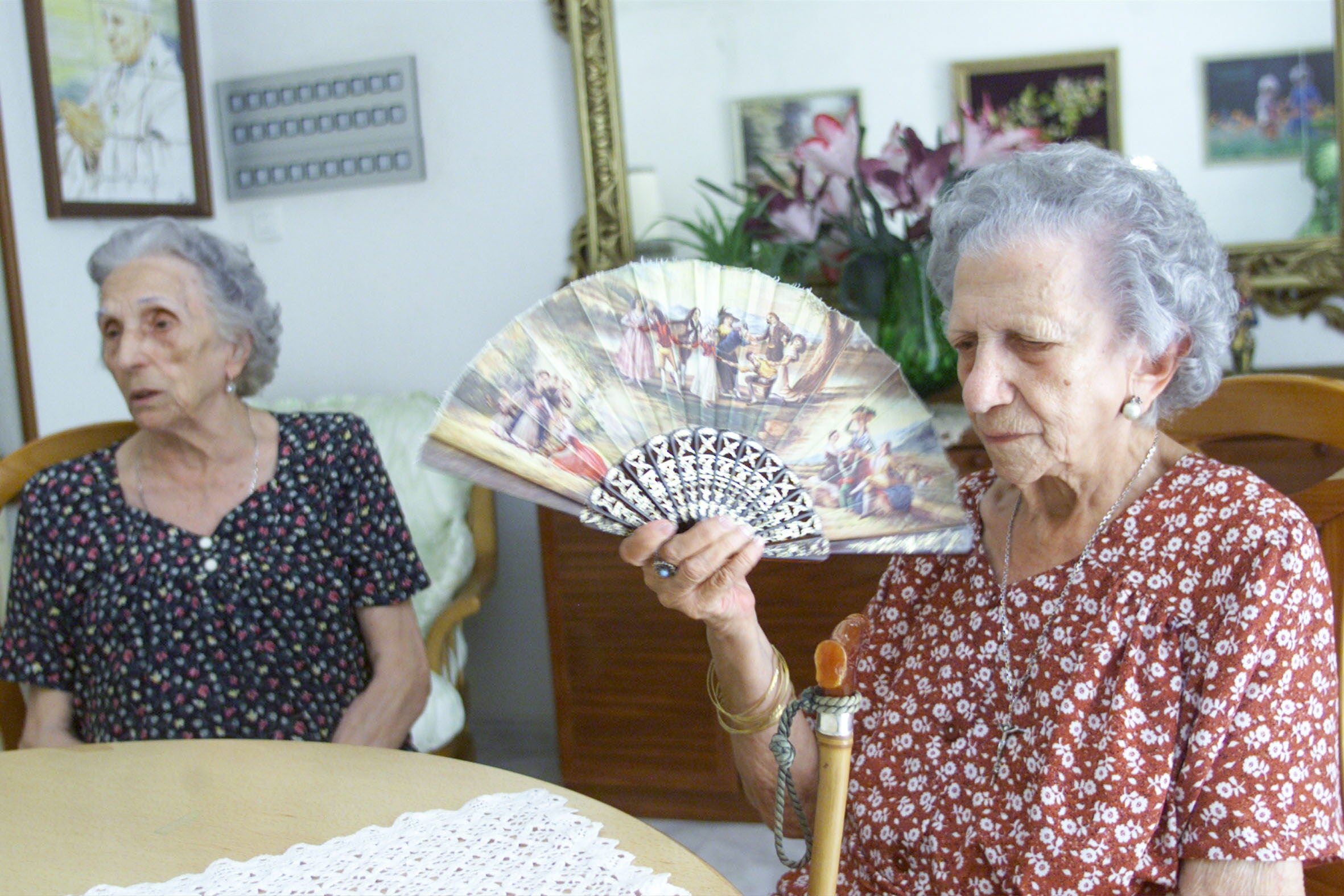 Dos mujeres abanicándose por el calor.