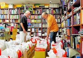 José Luis Marín, a la derecha, prepara los lotes de libros de texto para su clientes en la librería Colón de Badajoz.