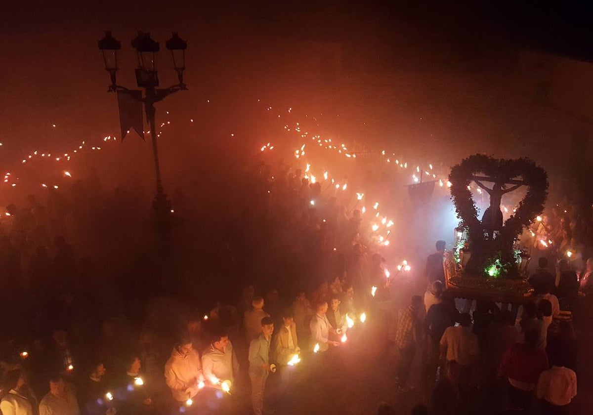 El Cristo de las Misericordias es portado entre antorchas por la plaza de España.