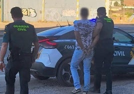 Agentes de la Guardia Civil se llevan esposado al hombre arrestado.