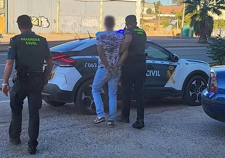 Agentes de la Guardia Civil se llevan esposado al hombre arrestado.