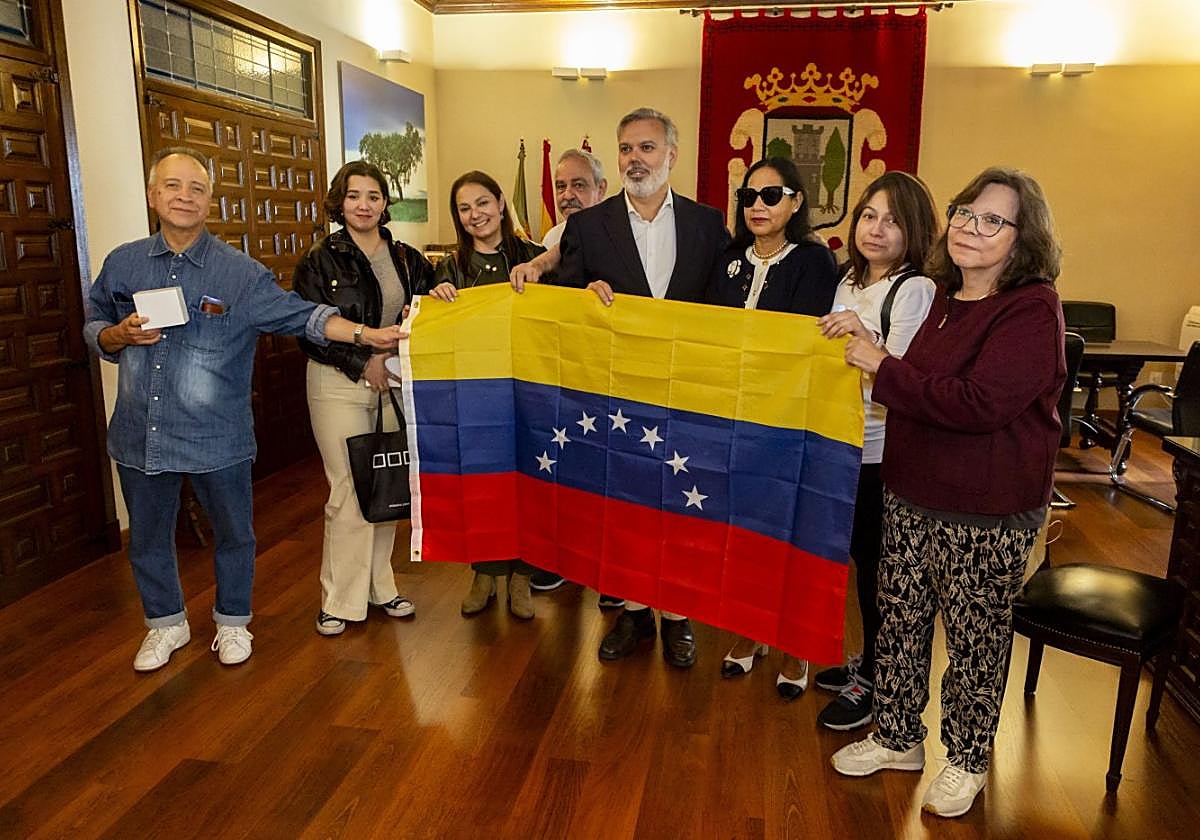 Los venezolanos en Plasenciamuestran ante elalcalde su bandera legítima, lade las siete estrellas.