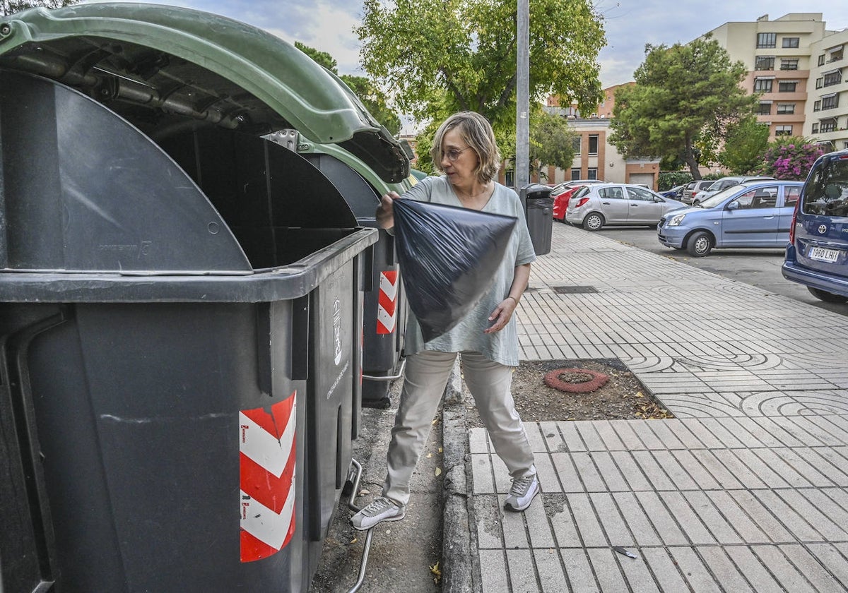 Una pacense deposita una bolsa de basura en un contenedor de la avenida de Godofredo Ortega y Muñoz.