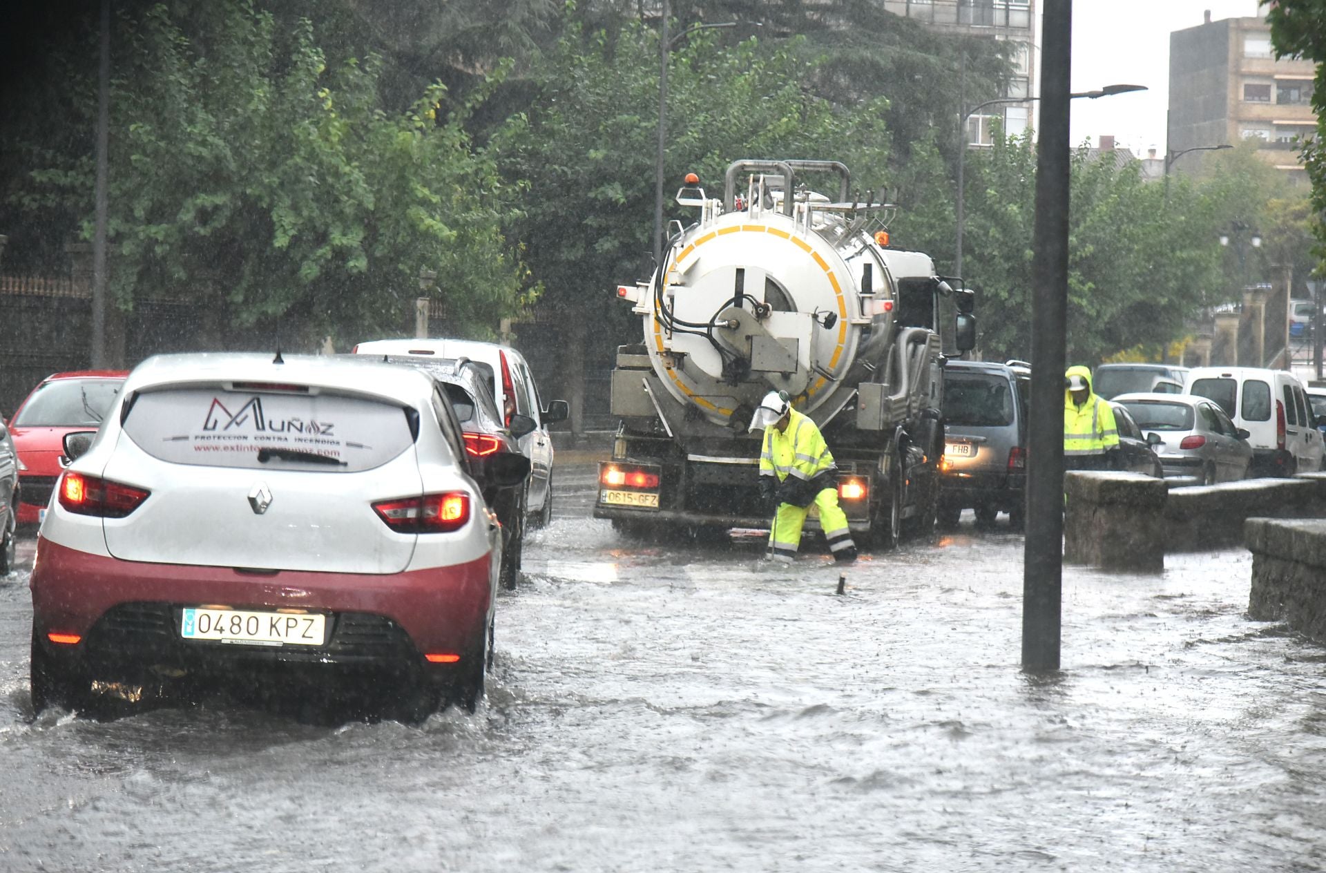 Operarios del Ayuntamiento de Plasencia achican agua en una vía anegada.