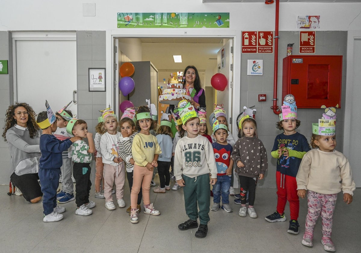 Imagen principal - Los niños posaron ante la puerta de la biblioteca, donde fue colocado el vinilo con el nombre de la profesora. 