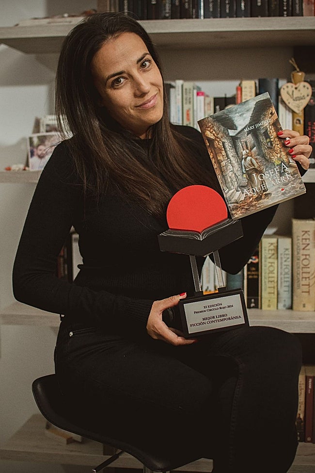 Jiménez posa en su casa de La Morera con el trofeo y su novela, ambientada en Llerena y cuya protagonista es una mujer de Aceuchal.