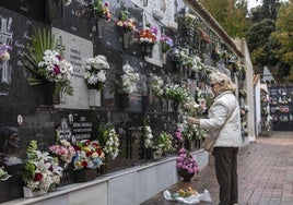 Una mujer colocaba flores este jueves en un nicho del cementerio municipal de Cáceres.