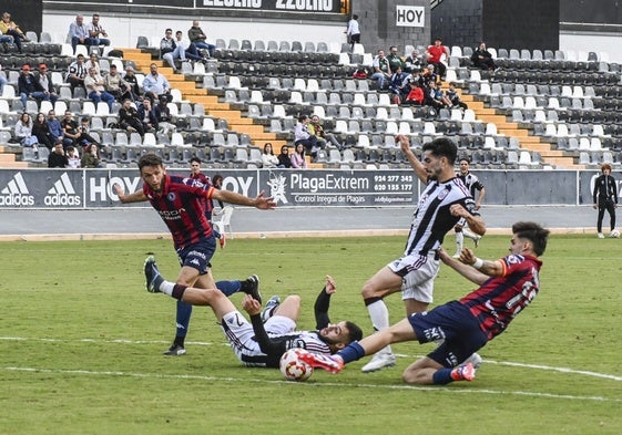 Los blanquinegros Bermúdez y Montori entre los azulgranas Miguel Núñez y Cidoncha durante el partido Badajoz-Extremadura.