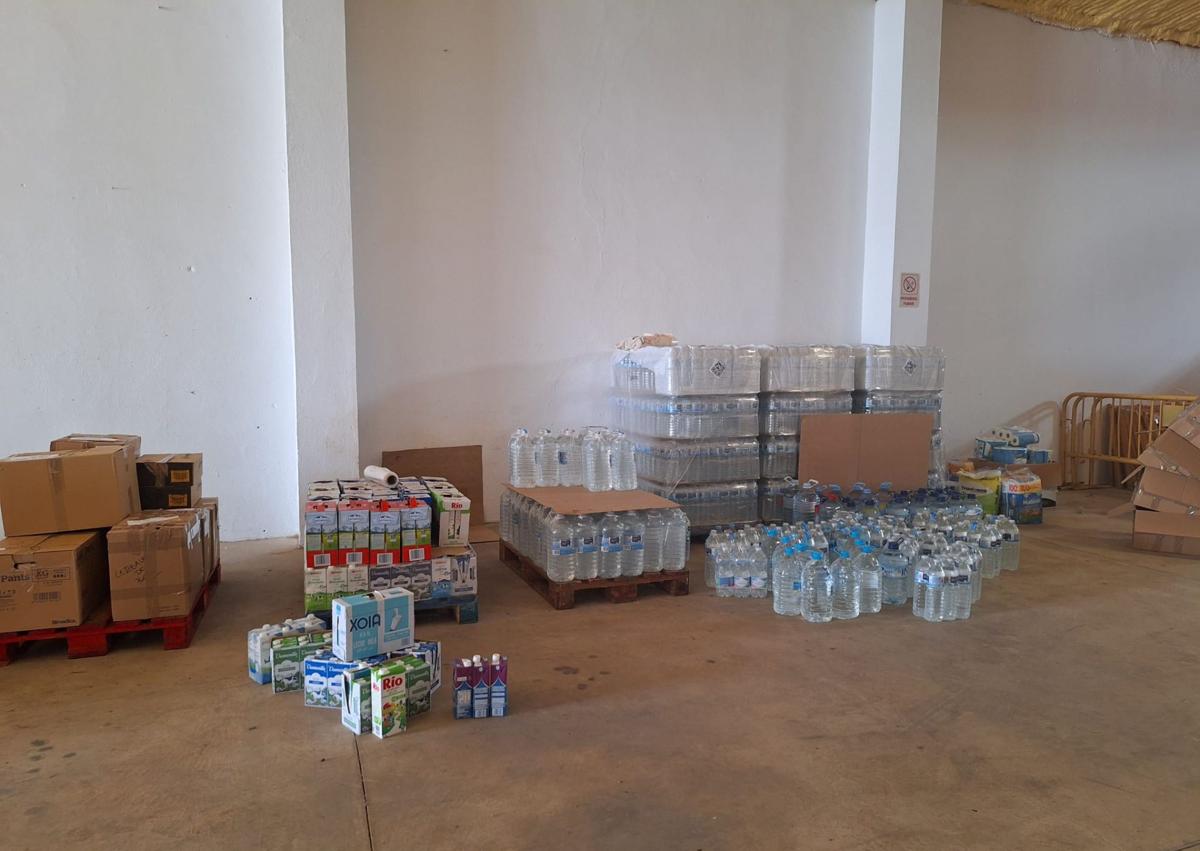 Imagen secundaria 1 - Arriba, grupo de voluntarias, este lunes, clasificando y emaquetando ropa. Abajo, a la izquierda, primeros palés y cajas de productos. A la derecha, taza solidaria que se pondrá en venta.