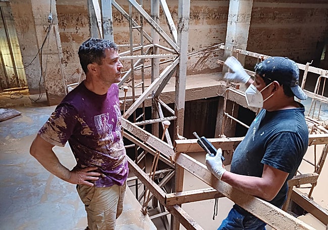 Alberto escuchando a otro voluntario en el sótano del edificio.