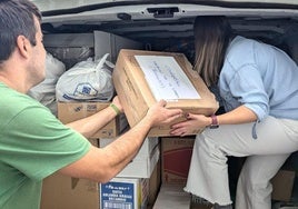 Jóvenes frexnenses llenando un coche con material de limpieza para llevar a Valencia.