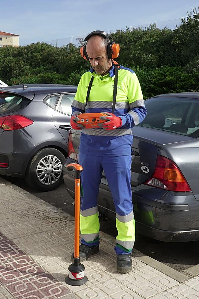 Uno de los operarios simula cómo sería la búsqueda de averías con el geófono.