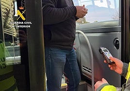 Un agente de la Guardia Civil realiza el test de alcoholemia a un conductor de autobús.