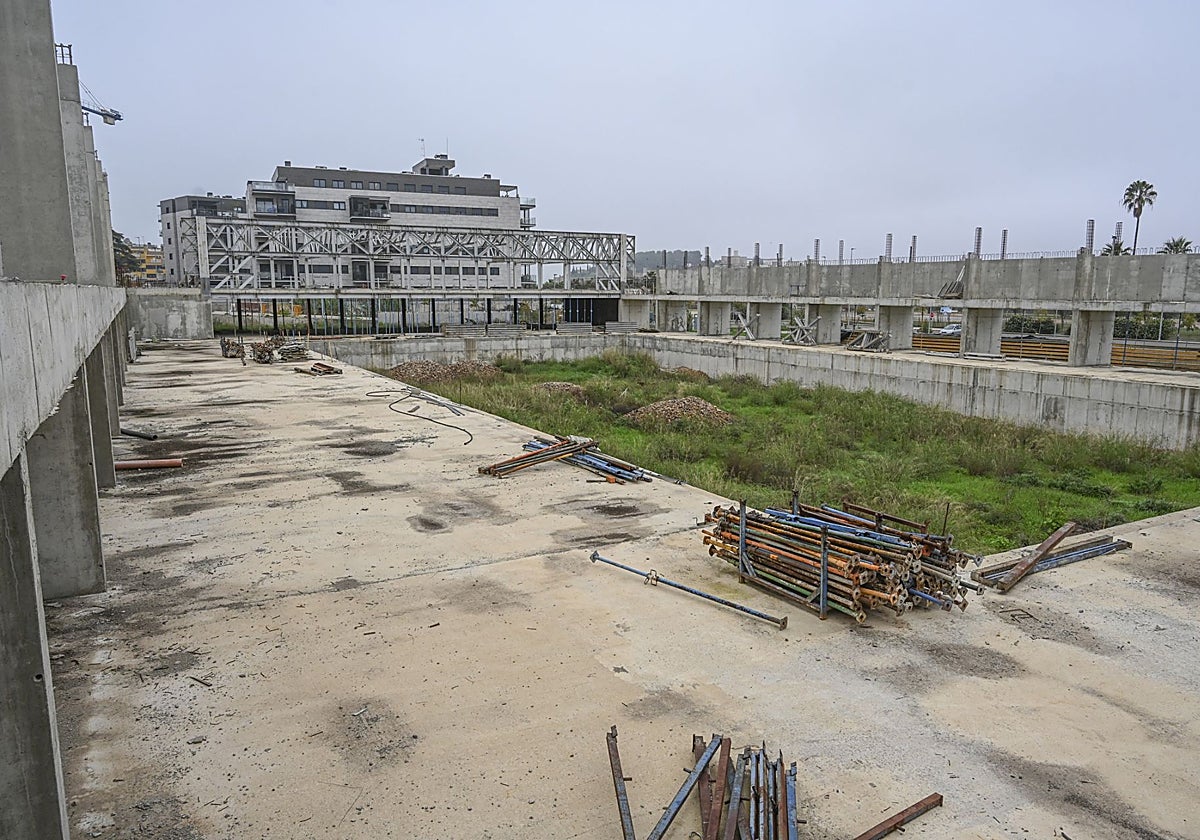 El foso de la piscina y puntales de hierro dentro del recinto acotado.