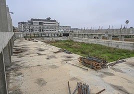 El foso de la piscina y puntales de hierro dentro del recinto acotado.