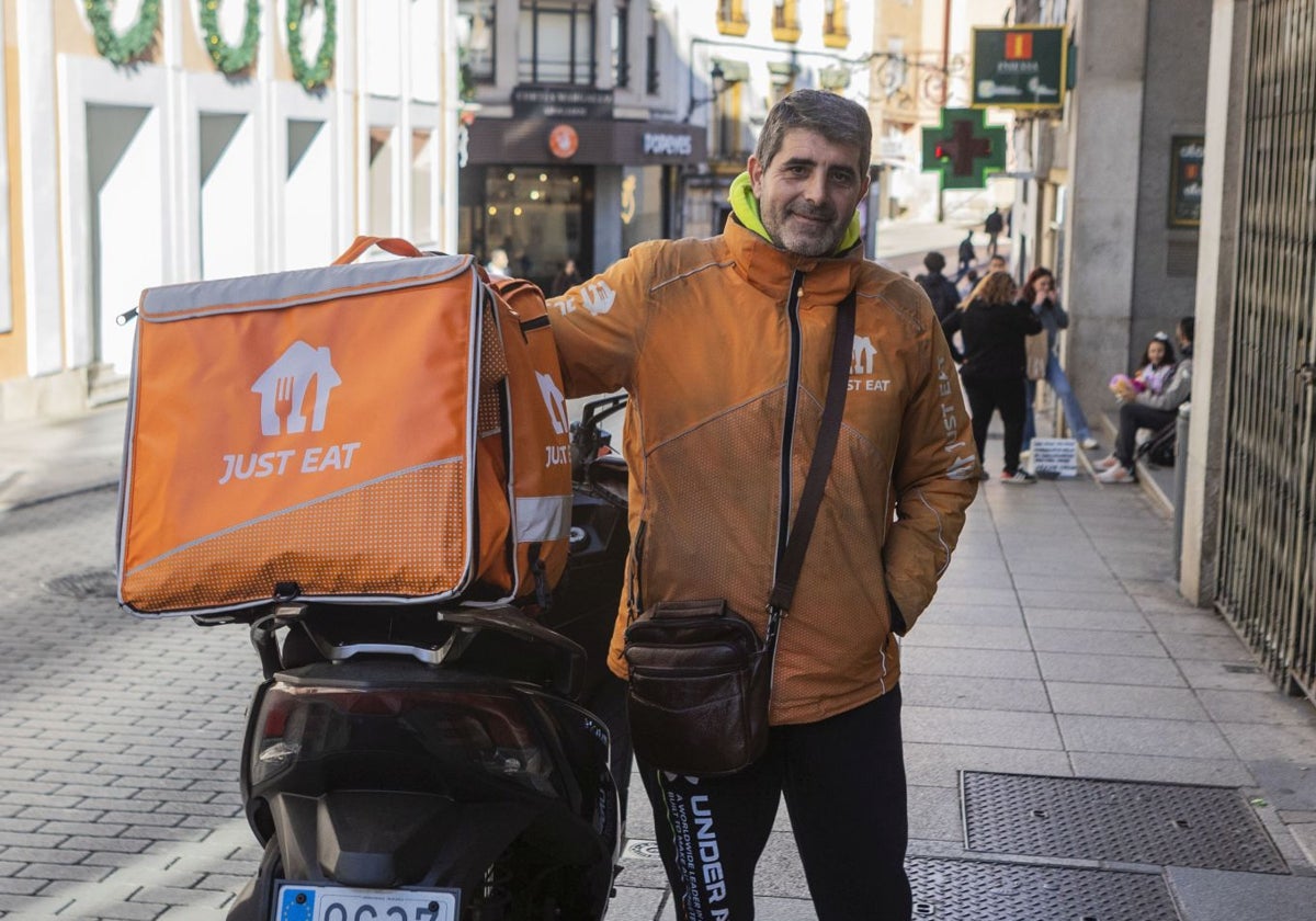 Javier Soria, trabajador de Just Eat, junto a su moto antes de recoger un pedido de comida a domicilio, en Cáceres.