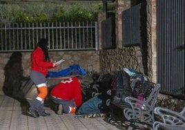 Dos voluntarios atienden a una persona sin hogar en la primera jornada del protocolo 'Ola de frío'.