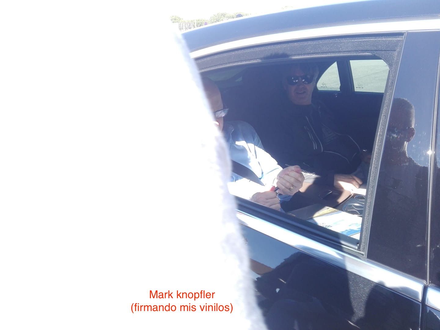 Mark Knopfler firmando en su coche.