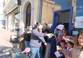 Algunos de los agraciados con el cuarto premio de la Lotería de Navidad en Montijo celebran en la puerta de la administración.