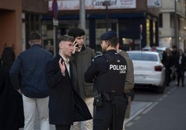 Un agente de la Policía Local en la plaza de los Alféreces atiende a varios ciudadanos el día de la Nochebuena.