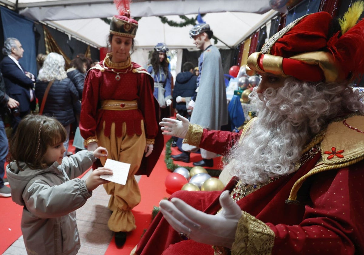 Una niña entrega su carta a Melchor, este sábado en el Paseo de Cánovas de la capital cacereña.