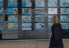 Foto de archivo de una mujer mirando ofertas de pisos.