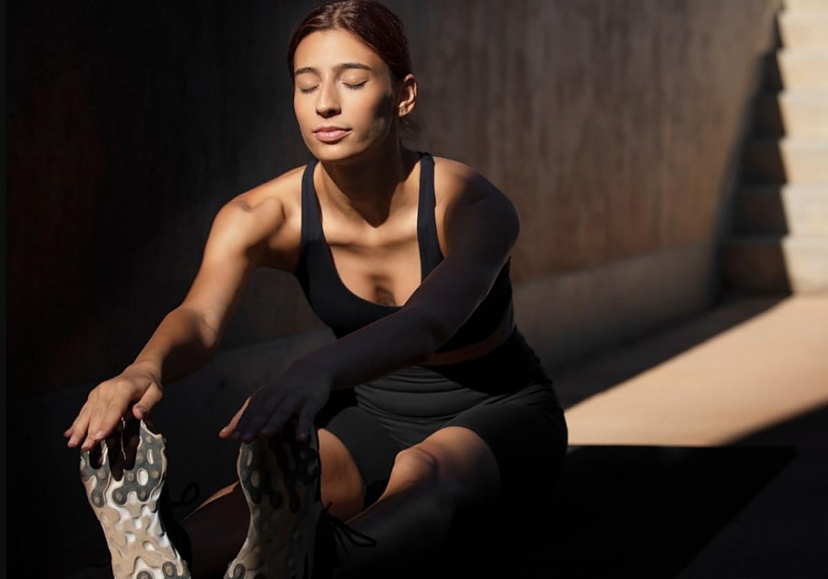 Persona estirando después de entrenar en ayunas por la mañana con el amanecer.