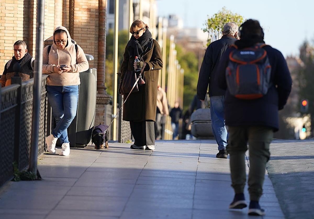 Personas abrigadas por las bajas temperaturas este martes, en Sevilla.