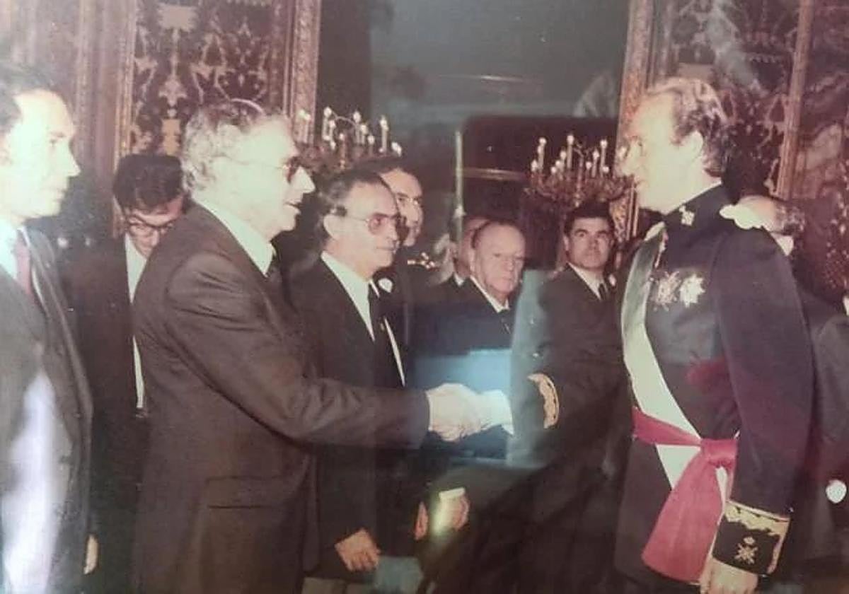 Luis Movilla estrecha la mano al rey Juan Carlos I durante una recepción oficial.