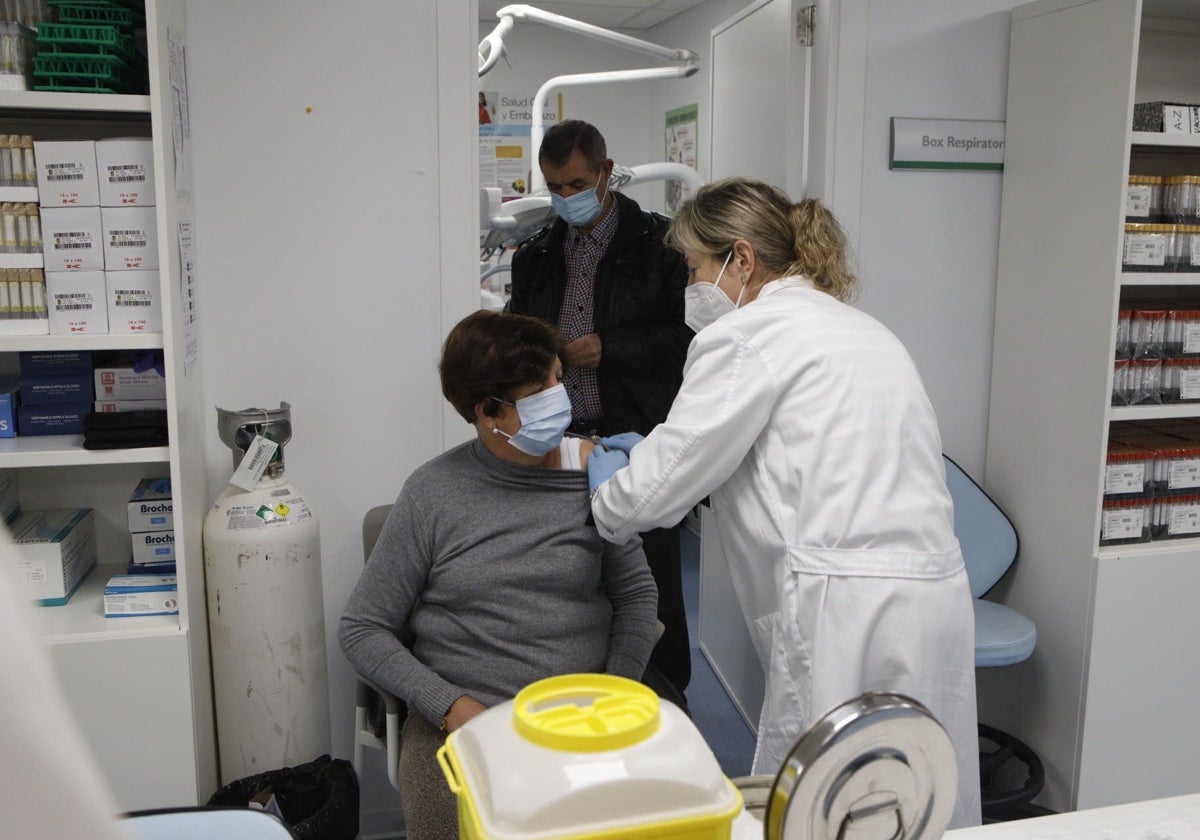 Una enfermera vacuna a una mujer de la gripe en Cáceres.