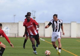 Gustavo Quezada conduce el balón presionado por Samed en el Azuaga-Badajoz.