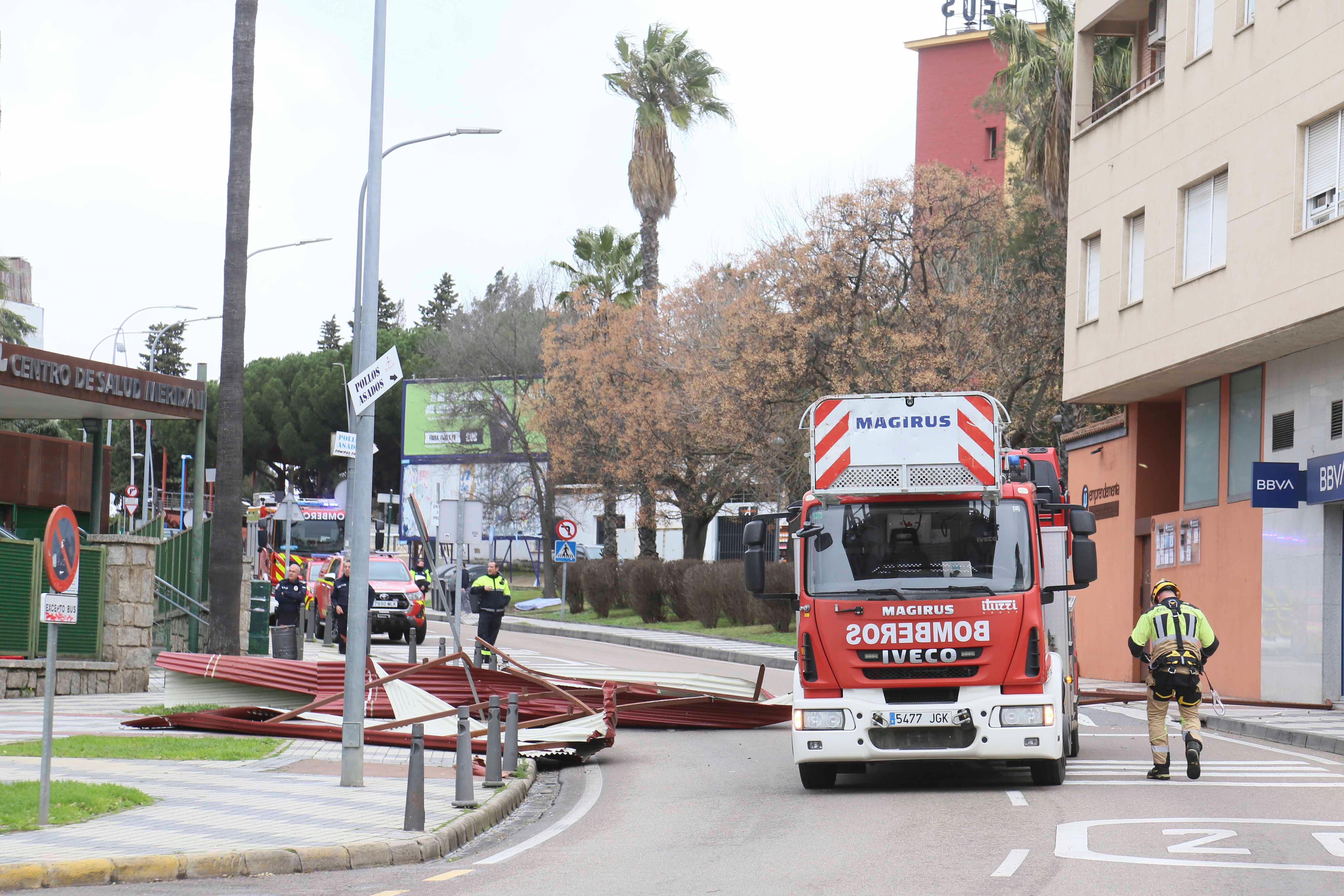 Bomberos del parque de Mérida y trabajadores del Ayuntamiento han retirado los restos de la cubierta del centro de Salud que ha volado.