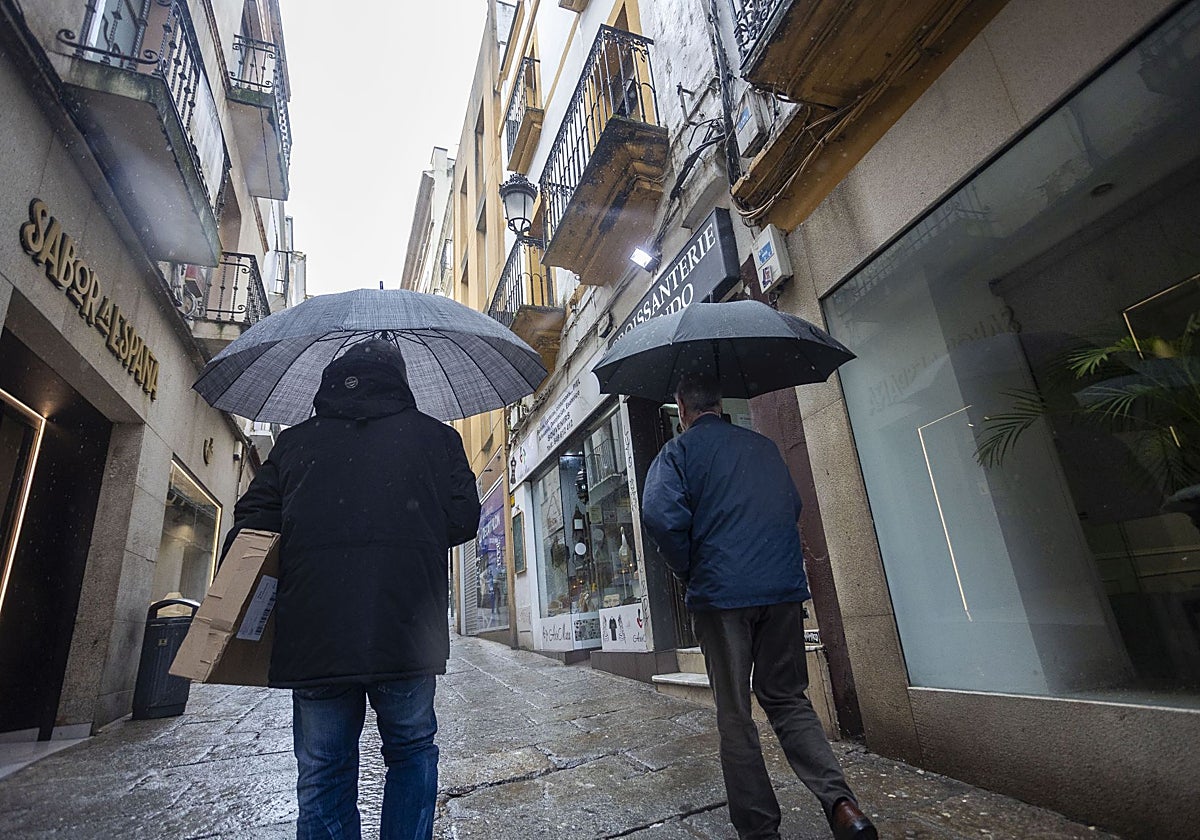 Dos personas se protegen de la lluvia en Cáceres en la última semana del pasado enero.