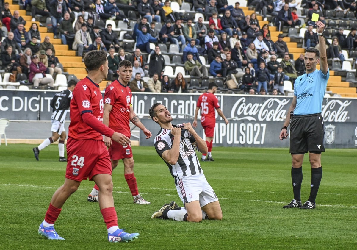 Álex Alegría recibe la amarilla por portestar un posible penalti.