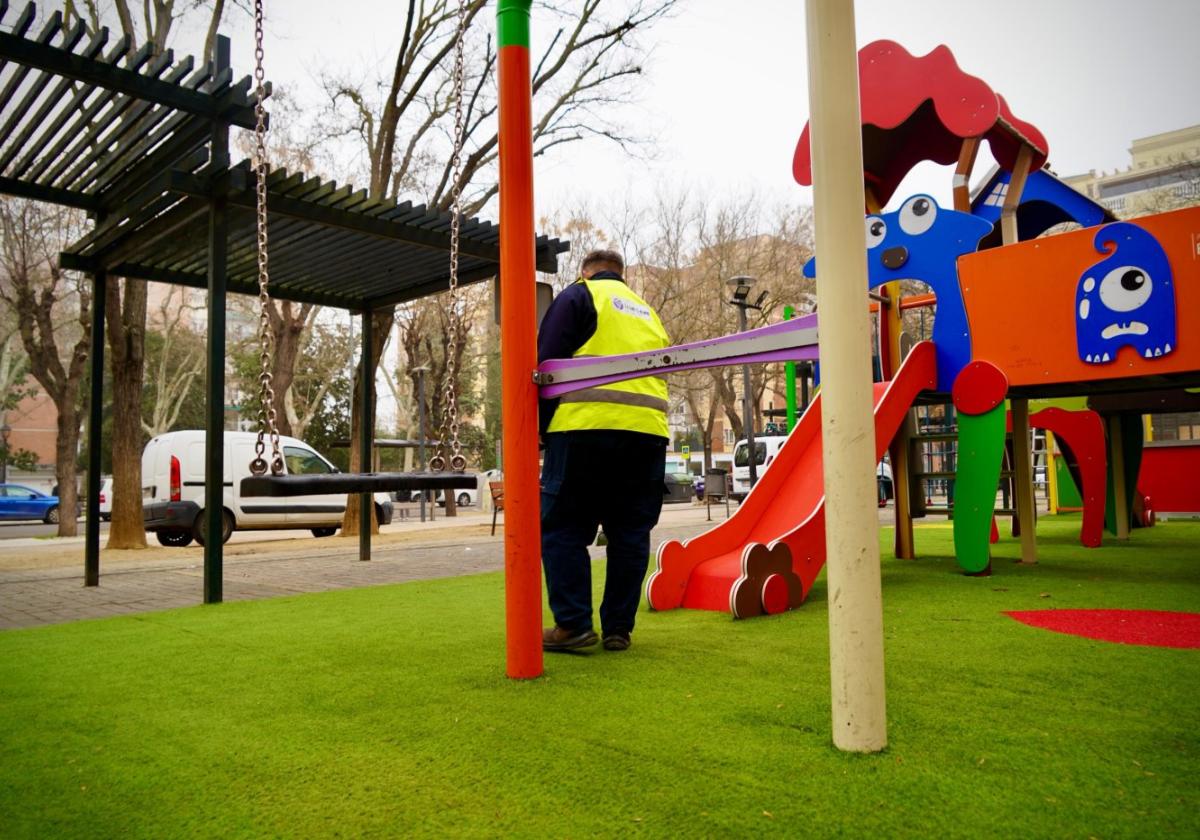 Un operario inspecciona un área de juegos infantiles de Badajoz.