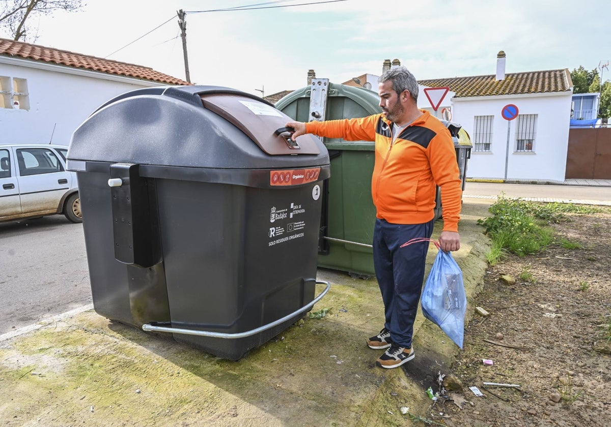 Un pacense deposita una bolsa de basura en el contenedor marrón.