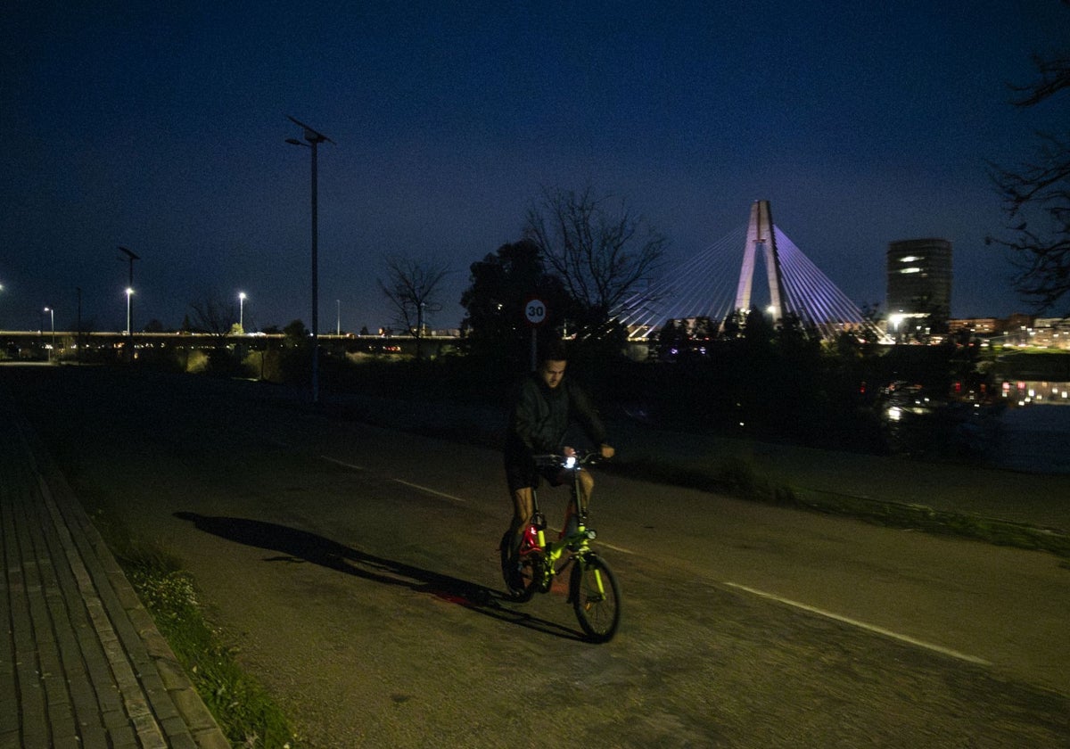 Un ciclista avanza a oscuras por el tramo en el que las farolas no funcionan.